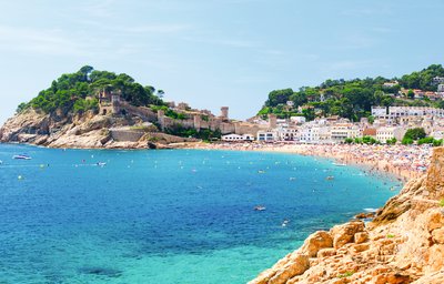 Eine wunderschöne Küste in Spanien bei gutem Wetter. Im Hintergrund befindet sich eine kleine Stadt im spanischen Stil.